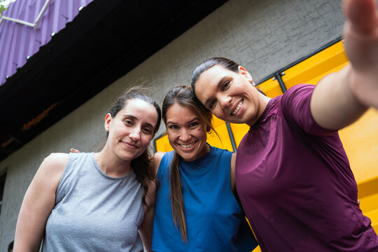 Three happy latin women friends enjoying a moment after workout, smiling and celebrating their fitness lifestyle and camaraderie