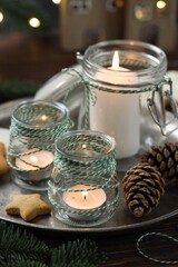 Christmas lanterns, cookies and festive decor on wooden table, closeup