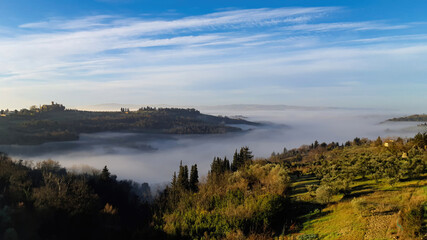 Tuscan hills covered by morning fog looking towards Montespertoli