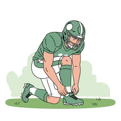 Football player in green uniform kneeling on the grass, tying his shoelaces before the game.
