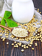 Flour soy in spoon on dark board