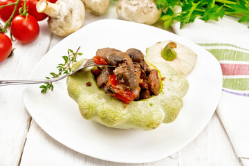 Patisson stuffed with liver and vegetables in plate on wooden board