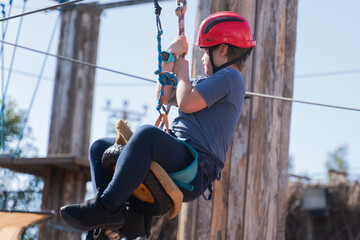 Child boy in Protective Gear Navigating a High Ropes Course in adventure park 
