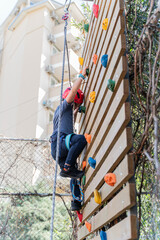 Child boy Rock Climbing on Outdoor Wooden Wall