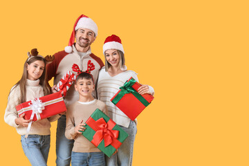 Happy family with Christmas presents on yellow background