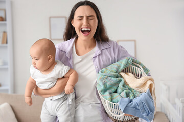 Screaming mother with her baby and laundry basket suffering from postnatal depression at home