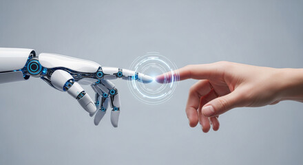 Close-up of a human hand touching a robotic hand on a gray backdrop with a glowing digital interface, illustrating futuristic interaction and artificial intelligence concepts. 