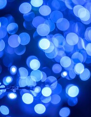 A close-up shot of blue bokeh lights against a dark background, creating a soft, blurred effect. Focus varies