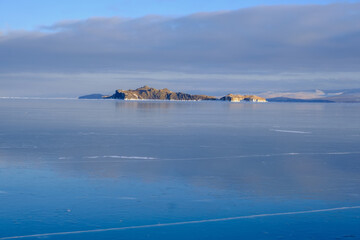 Baikal Lake in winter. Beautiful landscape with mountains reflected in ice of frozen Small Sea