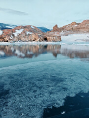 Baikal Lake in winter. Beautiful landscape with mountains reflected in ice of frozen Small Sea
