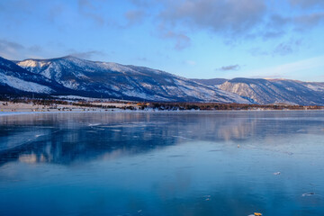 Baikal Lake in winter. Beautiful landscape with mountains reflected in ice of frozen Small Sea