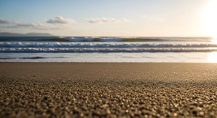 Close-up of textured beach sand in golden hour light, with the vast ocean and soft waves creating a tranquil backdrop, capturing the essence of a serene coastal landscape