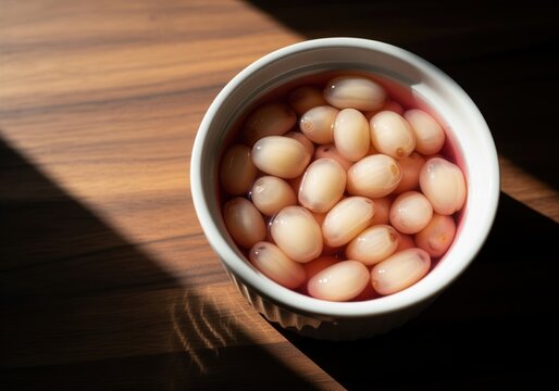 Delicious nipa palm fruit seeds dessert in pink syrup in a ceramic bowl