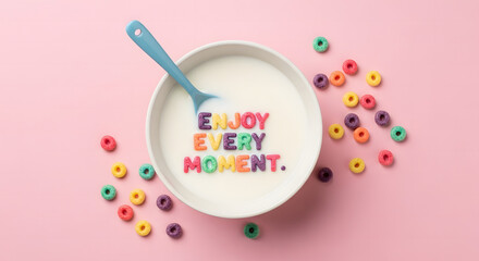 Colorful cereal rings spell out enjoy every moment in a bowl of milk