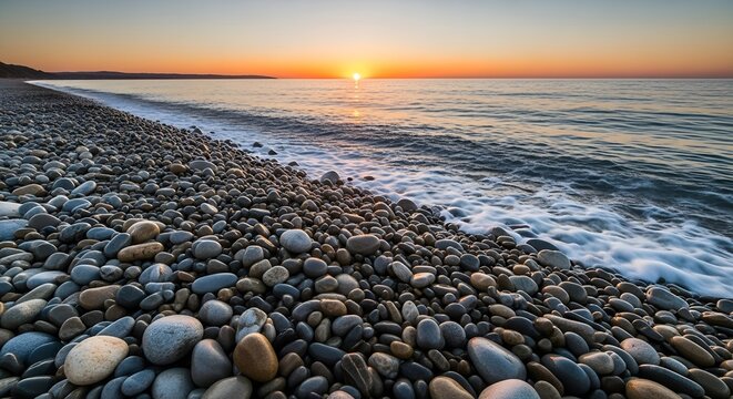 Pebble beach at sunrise calm ocean waves a peaceful and scenic landscape for travel and relaxation themes - Powered by Adobe