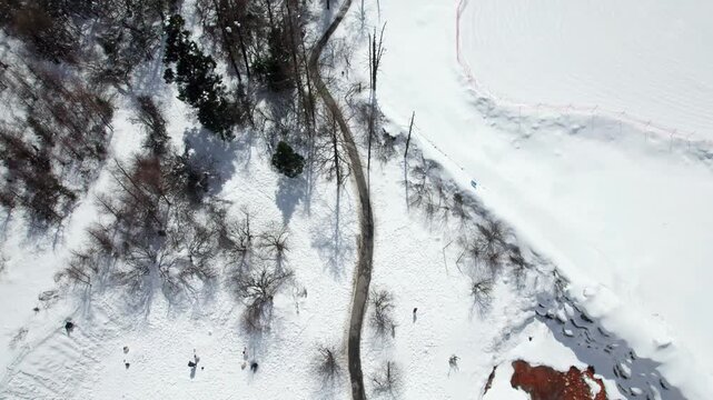 Drone view of snow covered mountains and forests in Bipeng Valley in Sichuan, China in sunny winter day, high angle view of beautiful winter landscape. 4k real time footage, travel concept.