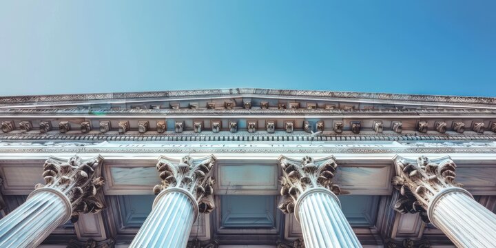 A grand, classical building with ornate columns and a blue sky in the background.