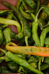 Discounted chili peppers with signs of ripening and slight imperfections displayed on a market stall