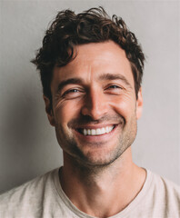 Genuine happy smiling young man portrait close up wide laugh joy emotion natural light studio beard white teeth excitement adult male face