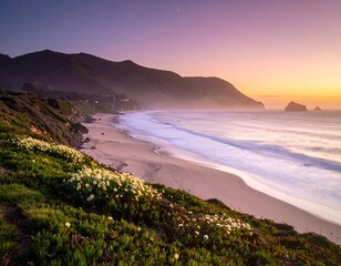A coastal scene at dusk, with gentle waves washing ashore a sandy beach. Green vegetation and mountains are visible