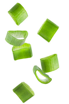dynamic photograph of freshly sliced green onion rings falling or floating in mid-air against a plain transparent background.