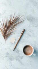 A flat lay composition featuring a dry palm leaf, a pen, a sticky note, and a cup of coffee on a textured surface.