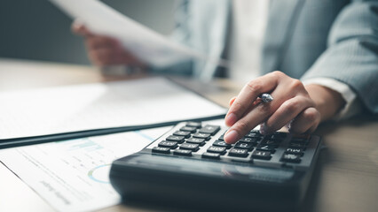 analysis, accounting, finance, budget, tax, Business person using a calculator and reviewing financial documents, representing accounting, budgeting, tax calculation, and financial analysis.