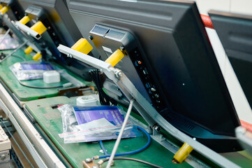Televisions being assembled on conveyor belt at electronics manufacturing facility in dynamic production environment