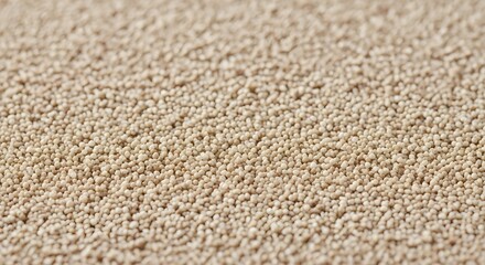 The granules appear dry and are spread across a surface, creating a texture that is dense and slightly fuzzy due to the shallow depth of field, which leaves the foreground sharp and the background blu