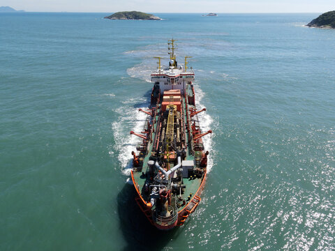 Aerial view of a dredging vessel operating offshore, showing the ship during maritime operation, suction dredger on the coast widening the sand strip beach.