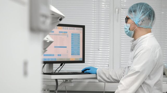 Scientist in blue gloves loading test tubes with blood samples into modern laboratory analyzer under bright clinical light in medical laboratory.