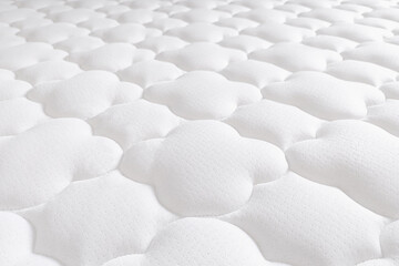 Soft white mattress surface with cloud-like quilting pattern texture, showing comfort, cushioning,...