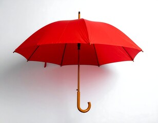 Vivid red umbrella, fully open, casting a subtle shadow against a plain white background. The handle is a rich brown color
