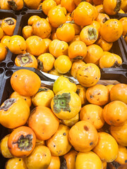 Persimmon pile sold on the market. Juicy, tasty and healthy persimmon in Azerbaijan