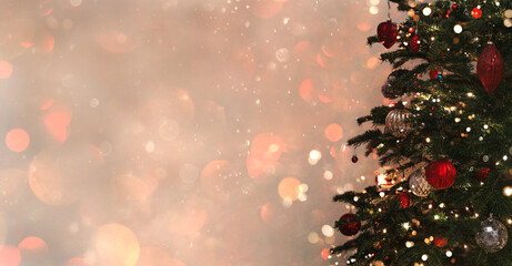 Christmas tree with red and silver decorations on dark background with bokeh, glowing. Merry Christmas and Happy New Year greeting card. Xmas and Winter holidays. Christmas wide banner, toning