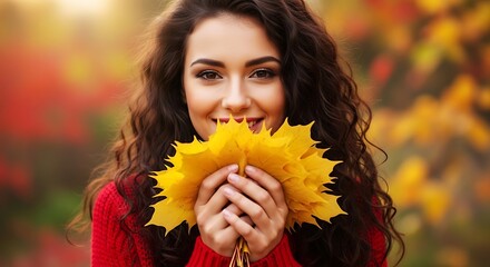Woman holding yellow leaves in autumn with a red sweater on