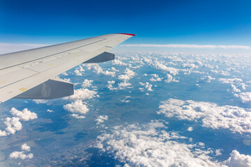 Obraz premium View from the airplane window at a beautiful cloudy sky and the airplane wing