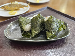 唐揚げにした渓流魚の鮎と、海苔を巻いたおにぎり。和食。