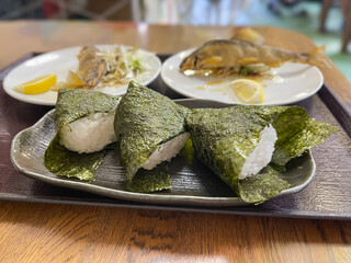 唐揚げにした渓流魚の鮎と、海苔を巻いたおにぎり。和食。