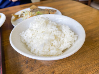 白米の炊き立てご飯と、唐揚げにした渓流魚の鮎。和食。