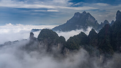 Picturesque mountain landscape. Peaks above the clouds. The blue sky. China. Tianmen Mountain