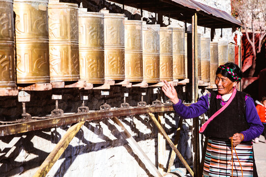 Local tibetan woman spinning prayer wheels, Tibet