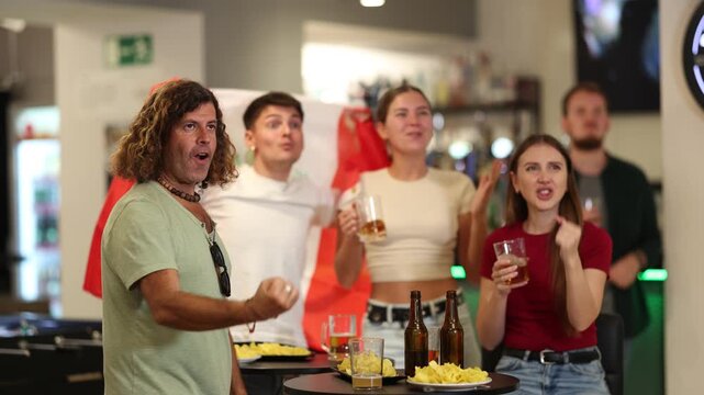 Happy man and woman sport fans holding flag of Peru, celebrating and drinking alcoholic drinks in beer pub. High quality 4k footage
