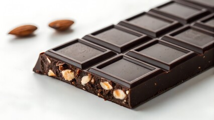 Dark Chocolate Bar With Almonds And Whole Almonds On A White Surface With Soft Lighting