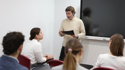 Knowledgeable professor explaining subject to classroom full of students - Powered by Adobe