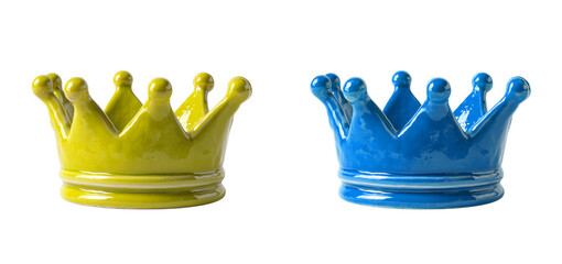 Two ceramic crowns in yellow and blue colors on a black studio background on transparent background