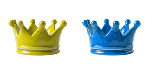 Two ceramic crowns in yellow and blue colors on a black studio background on transparent background