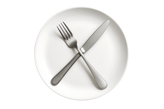 Polished silver fork crossed over a sharp dinner knife on a bright white round plate, a common dining etiquette signal indicating a finished or paused meal isolated on transparent background