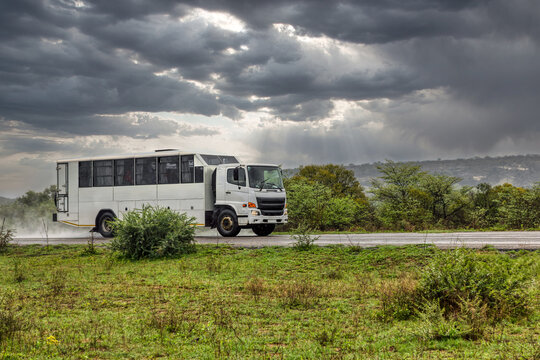 Remote Access Vehicle RAV converted bus body , on an open road in the heavy rain storm, transporting people personnel .