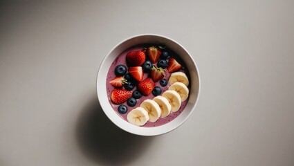 Vibrant & Healthy Purple Smoothie Bowl Topped with Fresh Organic Strawberries, Blueberries, and Sliced Bananas